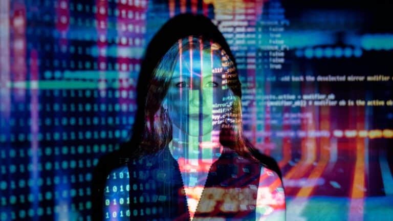 A women illuminated by the reflection of programming code